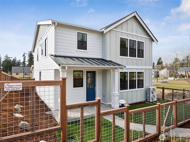 8310 115th Pl SE Unit 3, Newcastle, WA 98056 - view of front of property featuring board and batten siding, a fenced front yard, ac unit, a standing seam roof, and metal roof