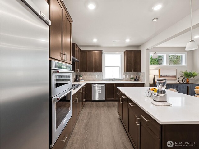 8310 115th Pl SE Unit 3, Newcastle, WA 98056 - kitchen featuring stainless steel appliances, a sink, dark brown cabinets, plenty of natural light, and recessed lighting
