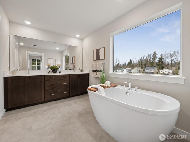 8310 115th Pl SE Unit 3, Newcastle, WA 98056 - full bath with double vanity, a soaking tub, recessed lighting, and baseboards