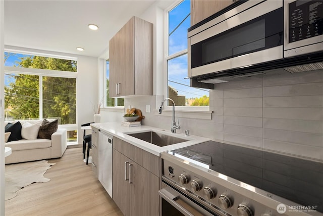 724 N 36th St, Seattle, WA 98103 - kitchen featuring appliances with stainless steel finishes, a sink, backsplash, healthy amount of natural light, and recessed lighting