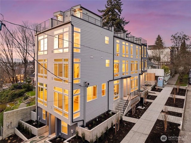 724 N 36th St, Seattle, WA 98103 - back of property at dusk with a balcony