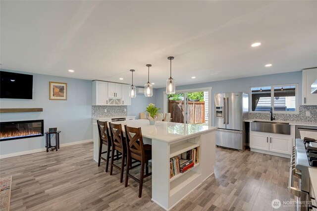 18008 Ashworth Ave N, Shoreline, WA 98133 - kitchen with stainless steel appliances, a sink, tasteful backsplash, light wood finished floors, and recessed lighting