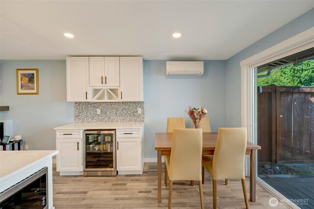 18008 Ashworth Ave N, Shoreline, WA 98133 - indoor dry bar featuring wine cooler, a wall unit AC, light wood finished floors, decorative backsplash, and stainless steel microwave