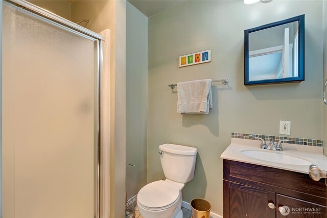 18008 Ashworth Ave N, Shoreline, WA 98133 - bathroom with a stall shower, vanity, toilet, baseboards, and backsplash