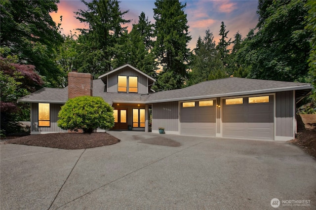19306 SE 21st St, Sammamish, WA 98075 - view of front of property featuring driveway, an attached garage, a shingled roof, and a chimney