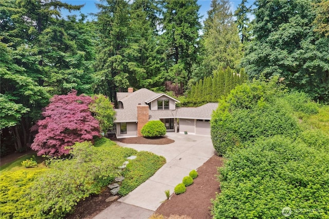 19306 SE 21st St, Sammamish, WA 98075 - view of front of home featuring concrete driveway, an attached garage, a view of trees, and a chimney