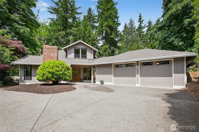 19306 SE 21st St, Sammamish, WA 98075 - view of front facade with a shingled roof, concrete driveway, an attached garage, a chimney, and french doors