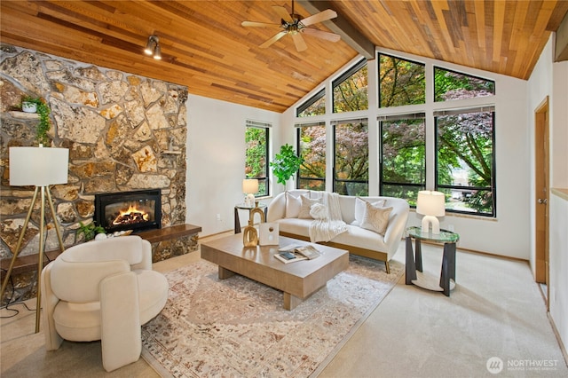 19306 SE 21st St, Sammamish, WA 98075 - living area featuring wooden ceiling with exposed beams, healthy amount of natural light, a ceiling fan, a stone fireplace, and baseboards