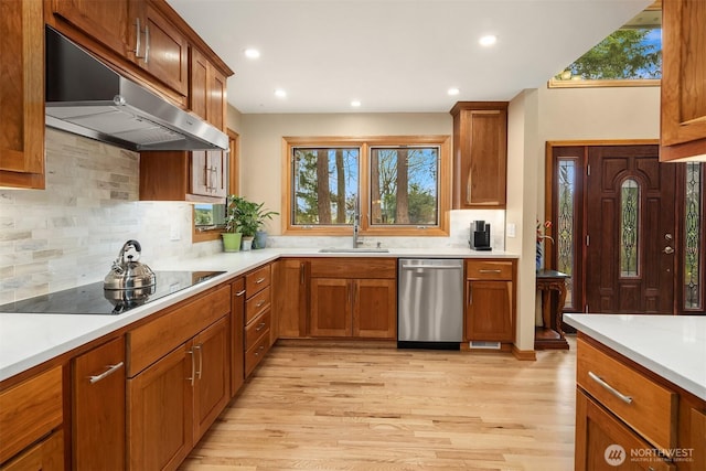 8521 E Mercer Way, Mercer Island, WA 98040 - kitchen with stainless steel dishwasher, under cabinet range hood, black electric cooktop, light wood-style floors, and light countertops