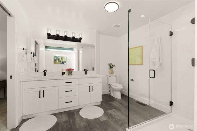 21024 NE 36th St, Sammamish, WA 98074 - full bath featuring toilet, a marble finish shower, double vanity, wood finished floors, and baseboards