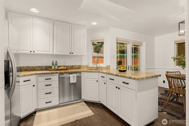 21024 NE 36th St, Sammamish, WA 98074 - kitchen featuring appliances with stainless steel finishes, a peninsula, a sink, light stone counters, and recessed lighting