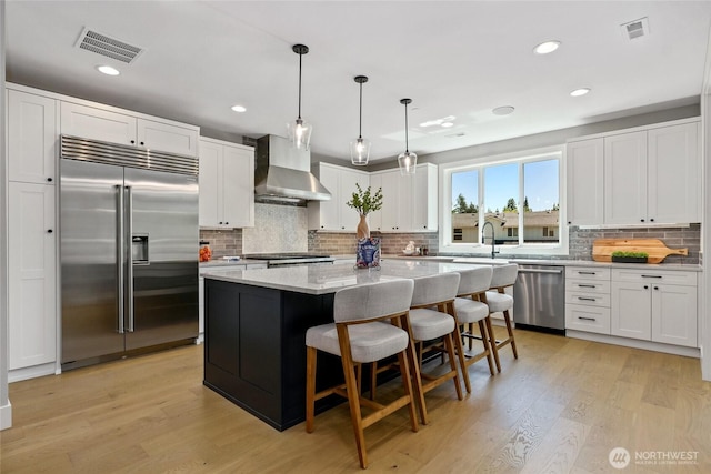 15535 NE 60th St, Redmond, WA 98052 - kitchen with stainless steel appliances, wall chimney range hood, white cabinets, and recessed lighting