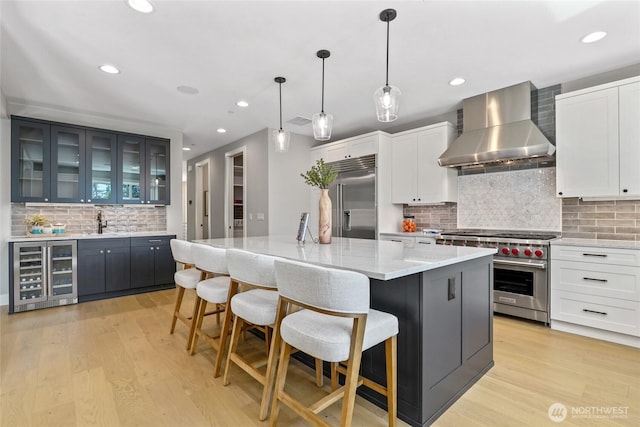 15535 NE 60th St, Redmond, WA 98052 - kitchen with wine cooler, high end appliances, wall chimney exhaust hood, tasteful backsplash, and a kitchen island