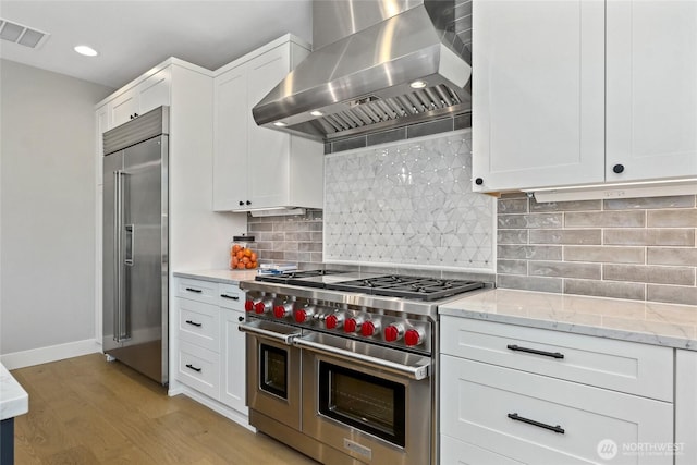 15535 NE 60th St, Redmond, WA 98052 - kitchen featuring high quality appliances, wall chimney exhaust hood, white cabinetry, and recessed lighting