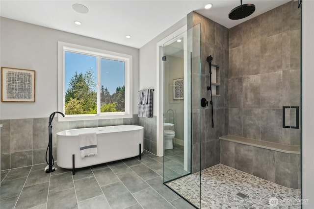 15535 NE 60th St, Redmond, WA 98052 - bathroom featuring tile walls, a stall shower, a freestanding bath, toilet, and tile patterned flooring