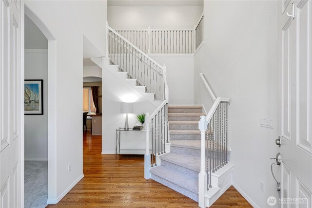 7817 NE 112th St, Kirkland, WA 98034 - stairs featuring arched walkways, wood finished floors, and baseboards