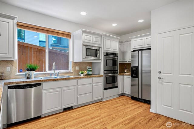 7817 NE 112th St, Kirkland, WA 98034 - kitchen featuring appliances with stainless steel finishes, a sink, white cabinetry, tasteful backsplash, and recessed lighting