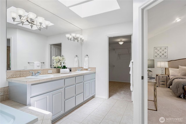 7817 NE 112th St, Kirkland, WA 98034 - bathroom featuring double vanity, a skylight, tile patterned flooring, a walk in closet, and a chandelier