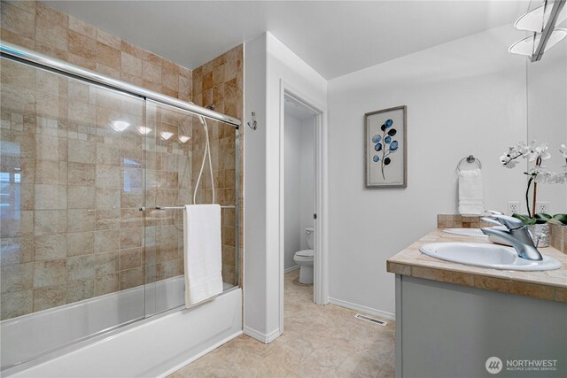 7817 NE 112th St, Kirkland, WA 98034 - bathroom featuring combined bath / shower with glass door, toilet, double vanity, and baseboards