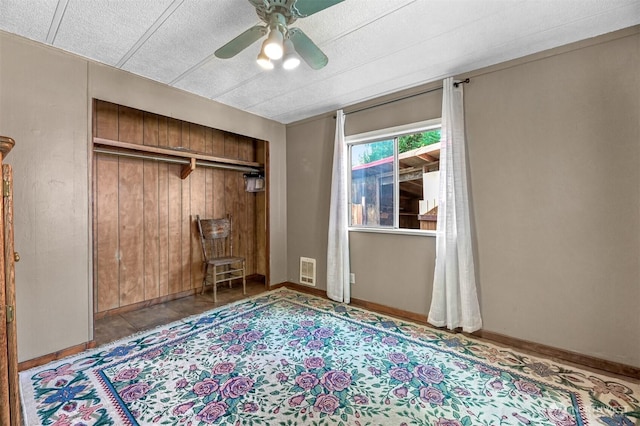 8445 Golden Valley Dr, Maple Falls, WA 98266 - unfurnished bedroom with a textured ceiling, a closet, a ceiling fan, baseboards, and wood walls