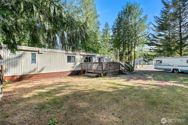 8445 Golden Valley Dr, Maple Falls, WA 98266 - back of house with a wooden deck, a lawn, and view of wooded area