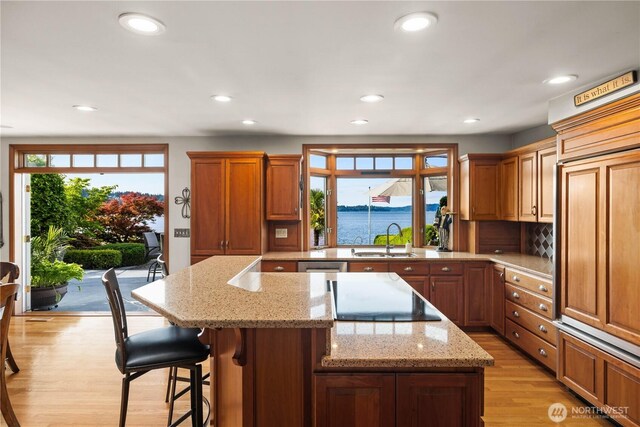 17834 SE 40th Pl, Bellevue, WA 98008 - kitchen with a sink, light wood-style floors, a center island, black electric cooktop, and recessed lighting