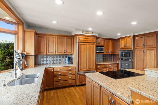 17834 SE 40th Pl, Bellevue, WA 98008 - kitchen featuring black electric cooktop, a sink, oven, stainless steel microwave, and light wood-style floors