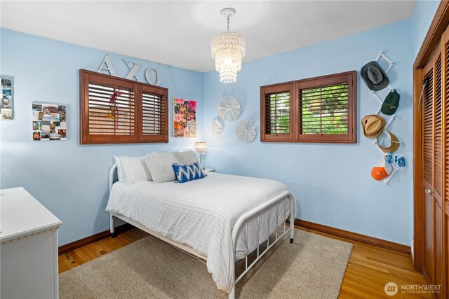 17834 SE 40th Pl, Bellevue, WA 98008 - bedroom featuring a chandelier, wood finished floors, and baseboards