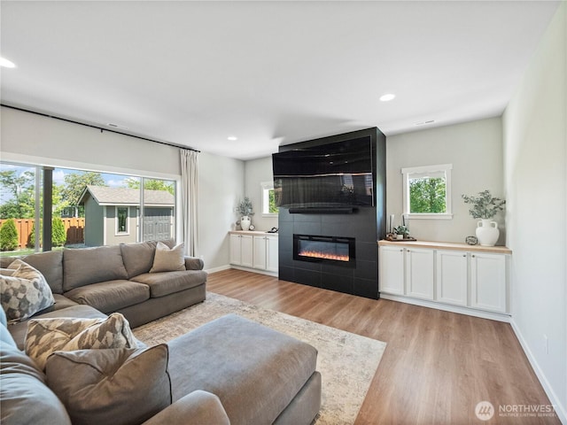 208 Hovey St, Buckley, WA 98321 - living area featuring light wood finished floors, a fireplace, recessed lighting, and baseboards