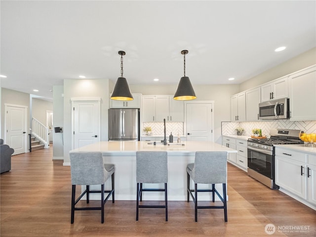 208 Hovey St, Buckley, WA 98321 - kitchen featuring appliances with stainless steel finishes, a sink, backsplash, white cabinets, and recessed lighting