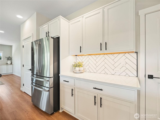 208 Hovey St, Buckley, WA 98321 - kitchen with freestanding refrigerator, backsplash, light countertops, light wood-type flooring, and recessed lighting
