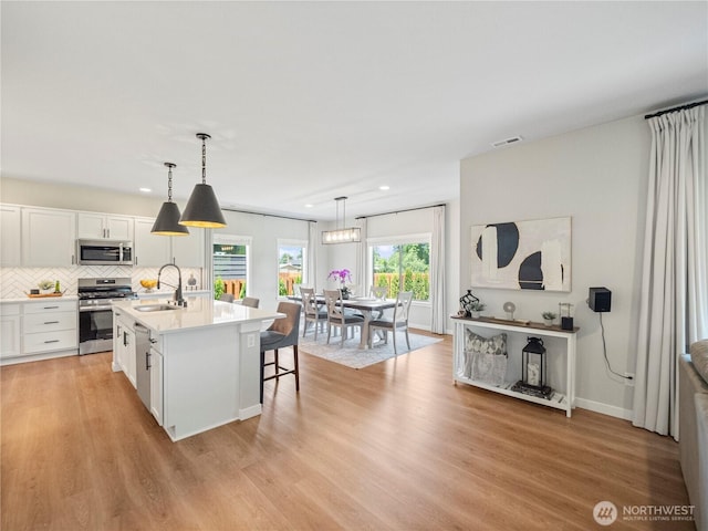 208 Hovey St, Buckley, WA 98321 - kitchen with appliances with stainless steel finishes, a sink, light countertops, white cabinetry, and recessed lighting