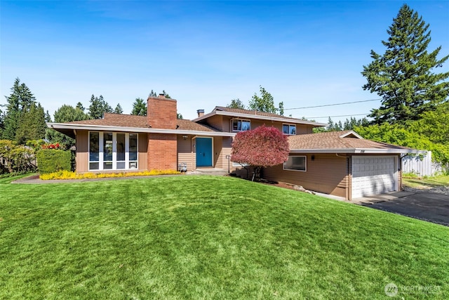 1981 Sequoia St SE, Port Orchard, WA 98366 - rear view of property featuring a chimney, a yard, driveway, and a garage