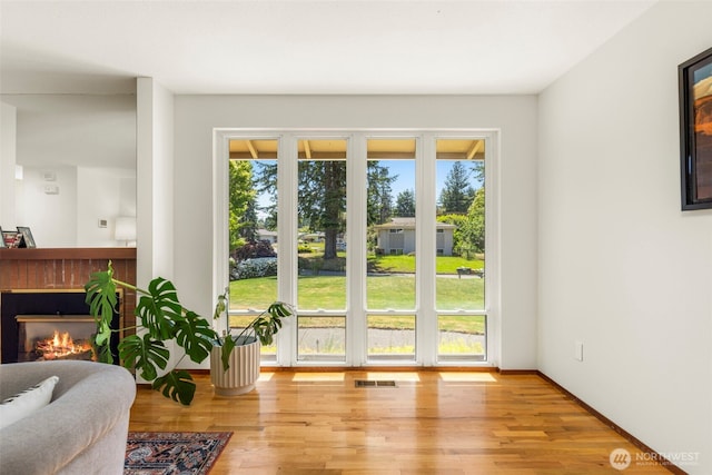 1981 Sequoia St SE, Port Orchard, WA 98366 - doorway with plenty of natural light, wood finished floors, and a lit fireplace