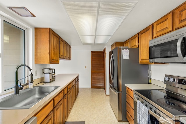 1981 Sequoia St SE, Port Orchard, WA 98366 - kitchen with appliances with stainless steel finishes, a sink, brown cabinetry, light flooring, and light countertops