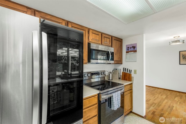 1981 Sequoia St SE, Port Orchard, WA 98366 - kitchen featuring appliances with stainless steel finishes, brown cabinetry, light countertops, and light wood-style floors