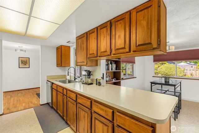 1981 Sequoia St SE, Port Orchard, WA 98366 - kitchen with a sink, dishwasher, light countertops, brown cabinetry, and a peninsula