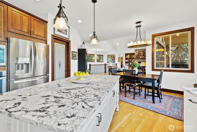 20 Longshore Ln, Bellingham, WA 98229 - kitchen with stainless steel refrigerator with ice dispenser, light stone counters, light wood finished floors, lofted ceiling, and brown cabinets