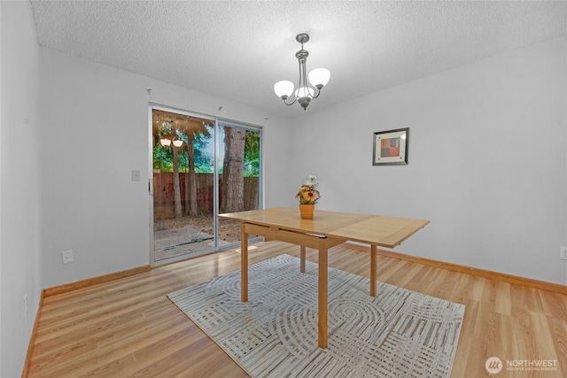 19029 56th Ln NE, Kenmore, WA 98028 - dining room with a chandelier, light wood finished floors, baseboards, and a textured ceiling
