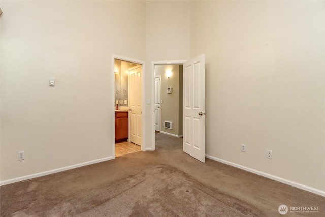 5513 Starlight St E, Fife, WA 98424 - unfurnished bedroom featuring light colored carpet, baseboards, a towering ceiling, and connected bathroom