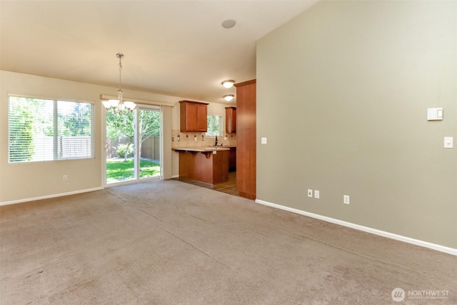 5513 Starlight St E, Fife, WA 98424 - unfurnished living room featuring a chandelier, baseboards, light carpet, and a sink