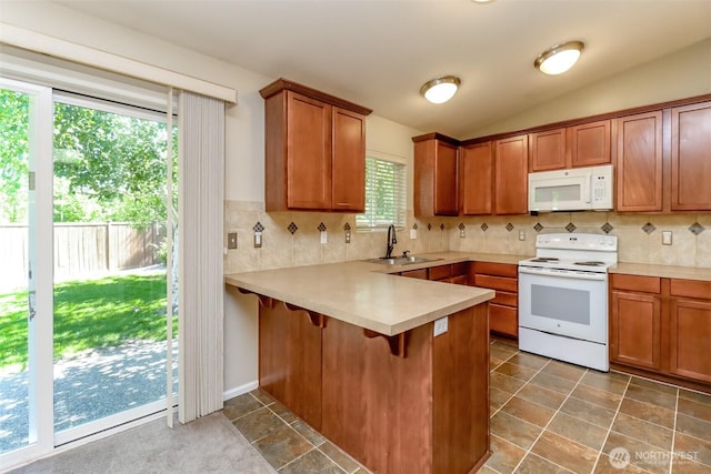 5513 Starlight St E, Fife, WA 98424 - kitchen featuring white appliances, a sink, brown cabinetry, a peninsula, and lofted ceiling