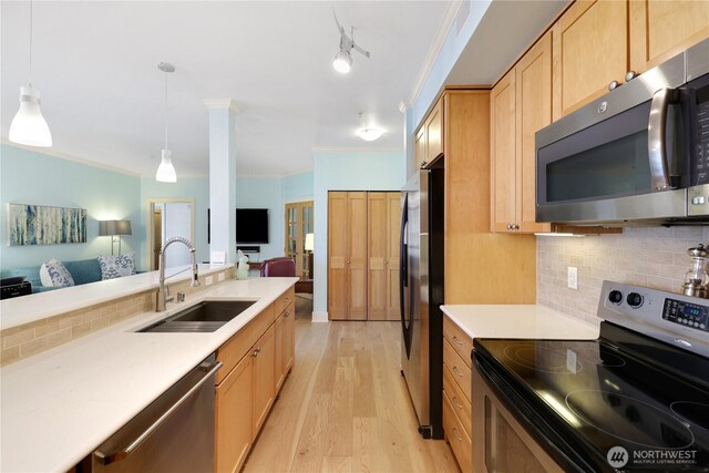 1501 Tacoma Ave S Unit 212, Tacoma, WA 98402 - kitchen with stainless steel appliances, a sink, open floor plan, ornamental molding, and light wood-style floors