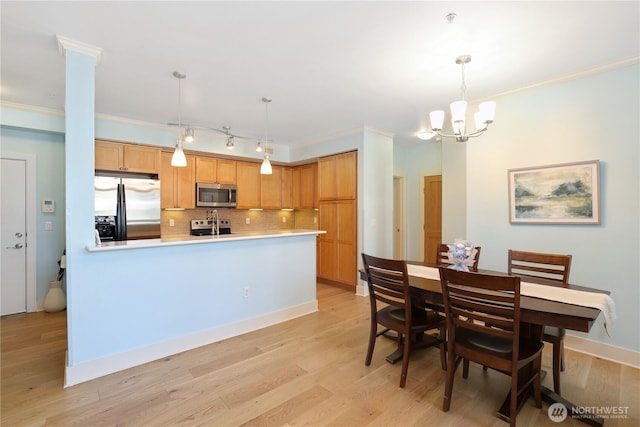 1501 Tacoma Ave S Unit 212, Tacoma, WA 98402 - dining room featuring ornamental molding, a chandelier, light wood-style floors, and baseboards