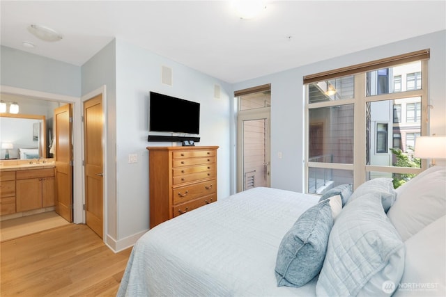1501 Tacoma Ave S Unit 212, Tacoma, WA 98402 - bedroom featuring light wood-style floors, a sink, ensuite bathroom, and baseboards