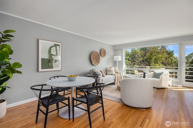 530 W Olympic Pl Unit 406, Seattle, WA 98119 - dining room with light wood-style floors, crown molding, and baseboards
