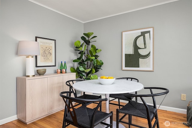 530 W Olympic Pl Unit 406, Seattle, WA 98119 - dining room featuring ornamental molding, light wood-style flooring, and baseboards