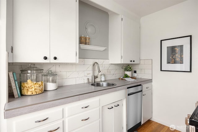530 W Olympic Pl Unit 406, Seattle, WA 98119 - kitchen with a sink, light countertops, tasteful backsplash, white cabinets, and dishwasher