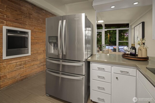 846 NE 104th St, Seattle, WA 98125 - kitchen with appliances with stainless steel finishes, white cabinets, light countertops, wooden walls, and recessed lighting