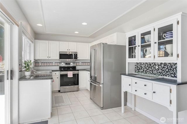 562 W Lake Samish Dr, Bellingham, WA 98229 - kitchen with appliances with stainless steel finishes, a sink, dark countertops, white cabinetry, and light tile patterned floors